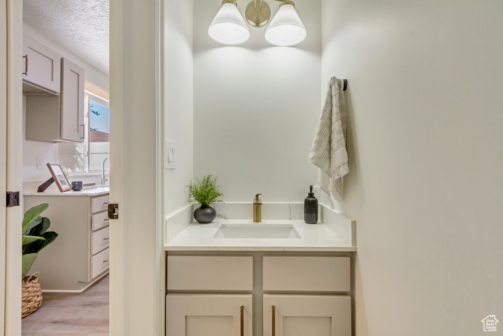 Bathroom featuring wood finished floors, a textured ceiling, and vanity