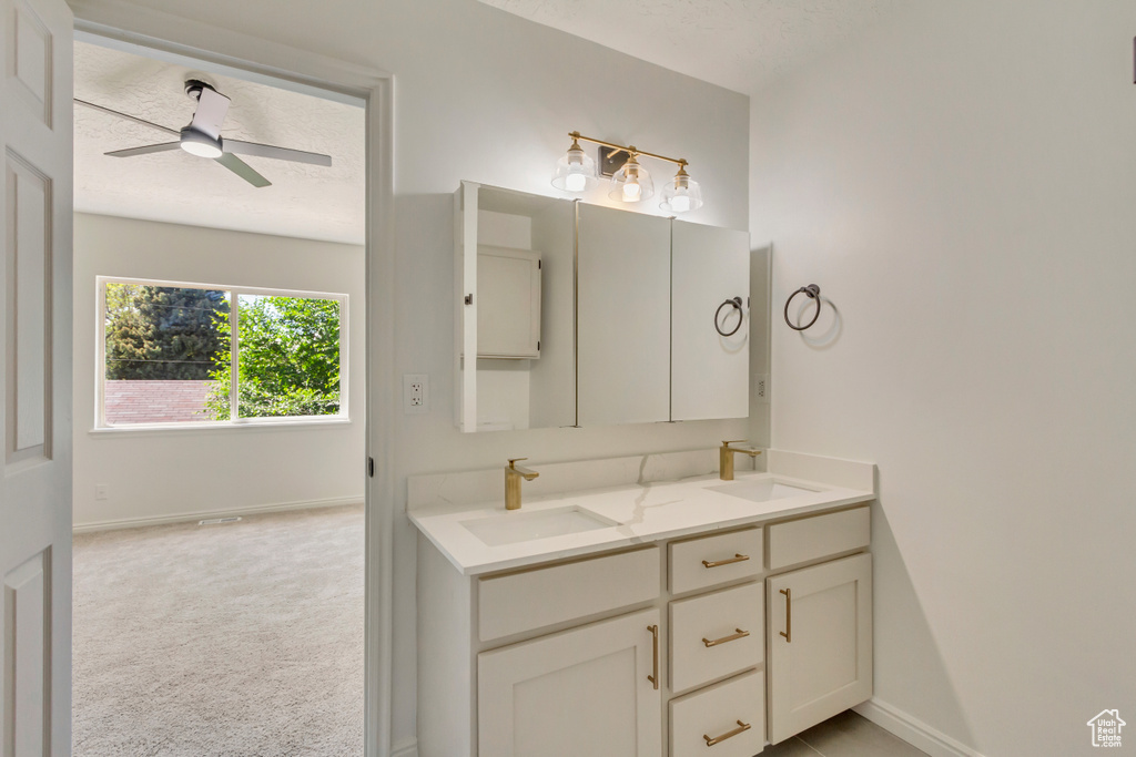 Bathroom featuring double vanity, baseboards, and a ceiling fan