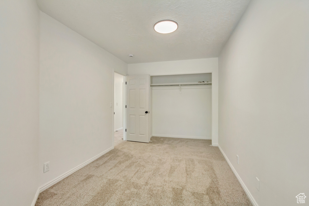 Unfurnished bedroom with carpet flooring, baseboards, and a closet