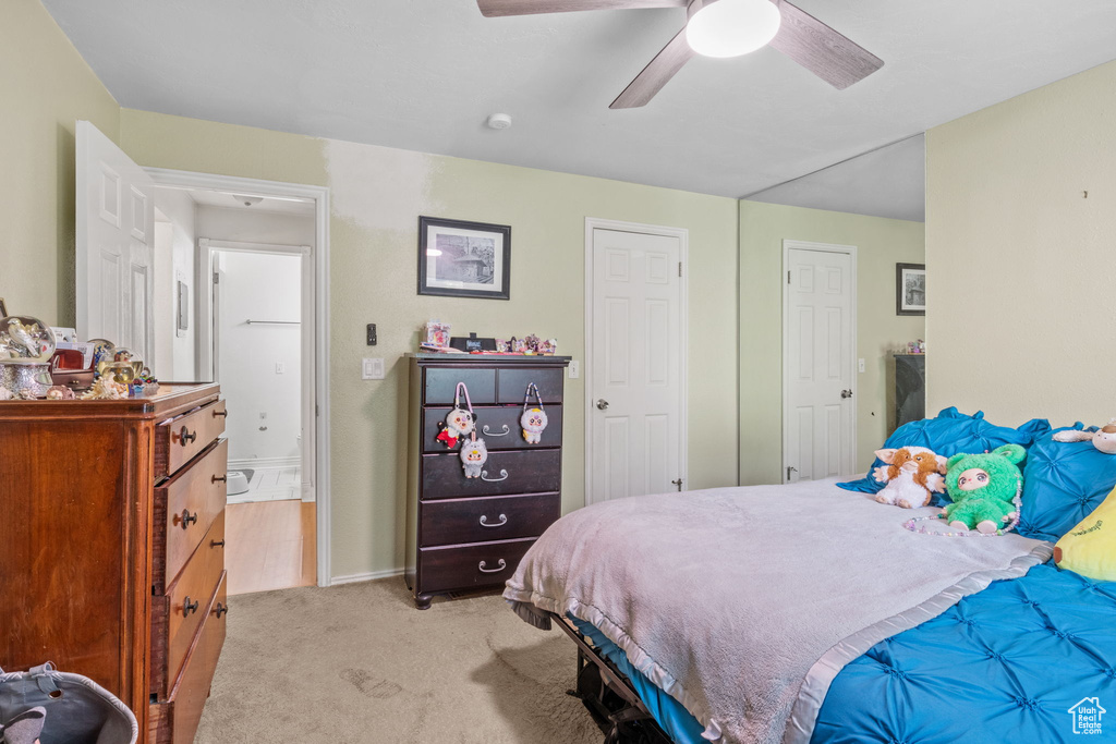 Bedroom featuring light carpet, a ceiling fan, and baseboards