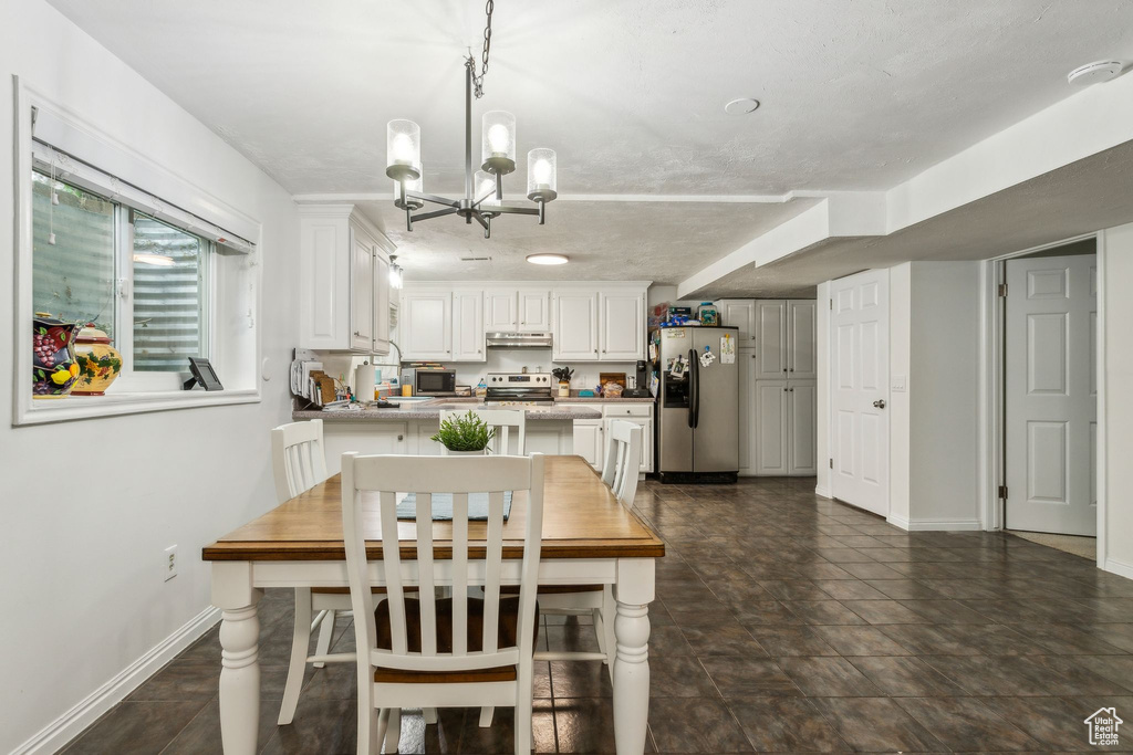 Dining room with a chandelier and baseboards