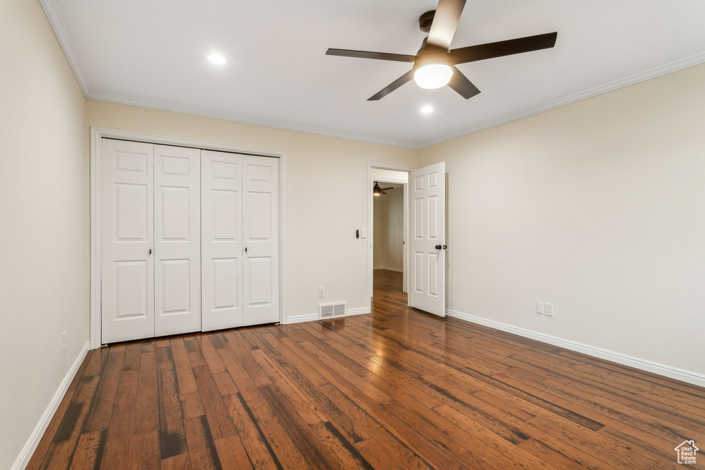 Unfurnished bedroom featuring dark wood-style floors, ornamental molding, baseboards, a closet, and recessed lighting