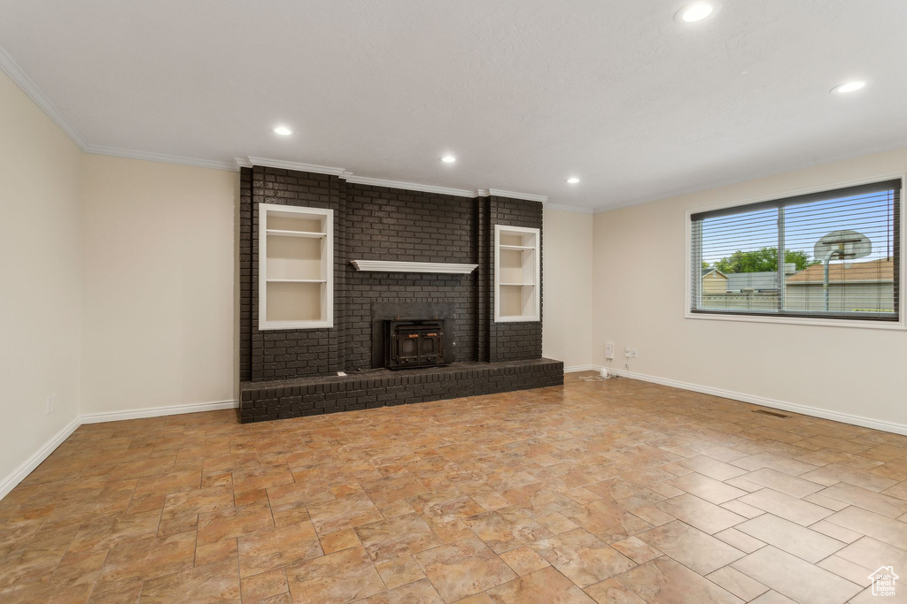 Unfurnished living room with baseboards, recessed lighting, crown molding, stone finish flooring, and a fireplace
