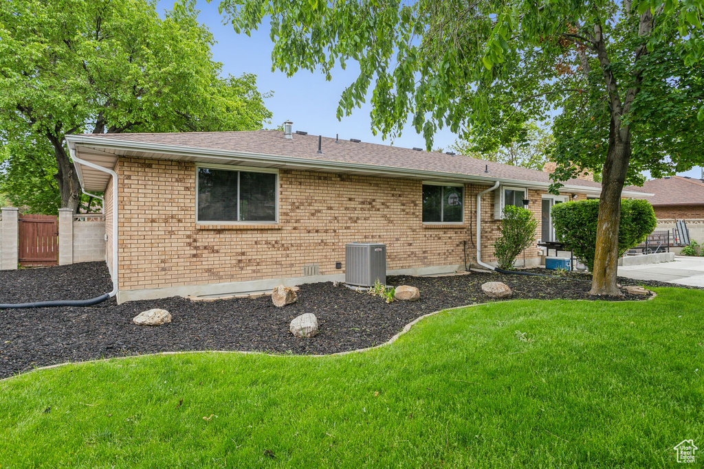 View of home's exterior featuring central AC, brick siding, roof with shingles, and a patio
