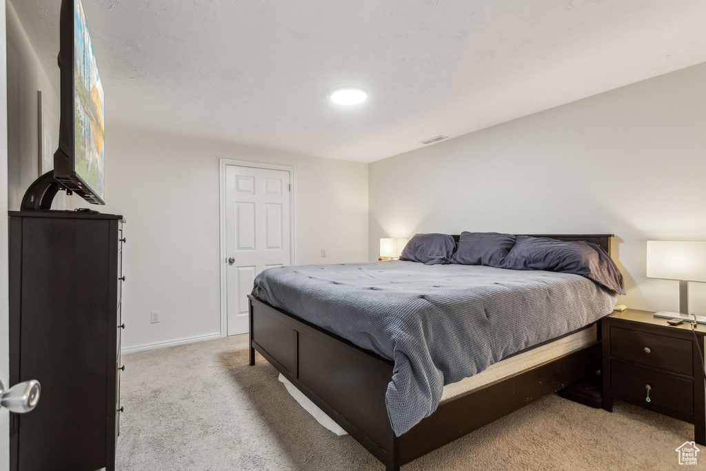 Bedroom with light carpet and baseboards