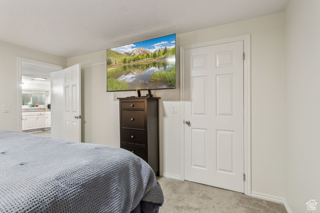 Bedroom featuring light colored carpet and baseboards