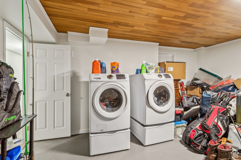 Clothes washing area with wooden ceiling, crown molding, and washing machine and dryer