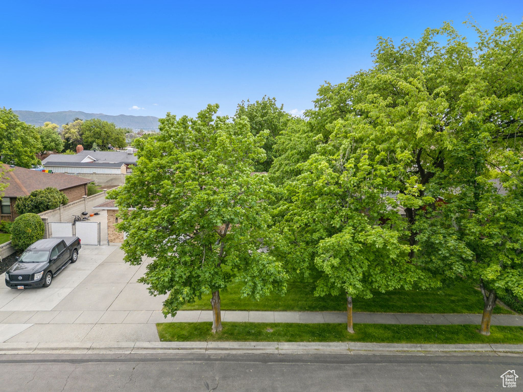 Obstructed view of property with driveway, an attached garage, and a mountain view