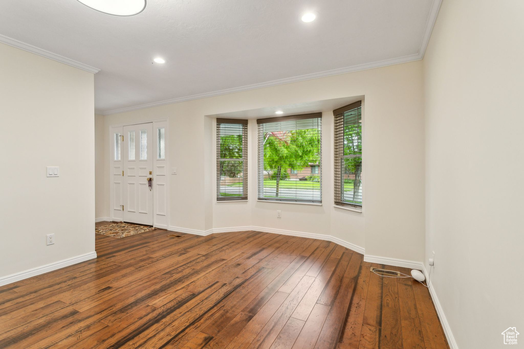Spare room featuring ornamental molding, wood-type flooring, baseboards, and recessed lighting
