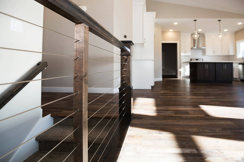 Staircase with wood finished floors, recessed lighting, and lofted ceiling