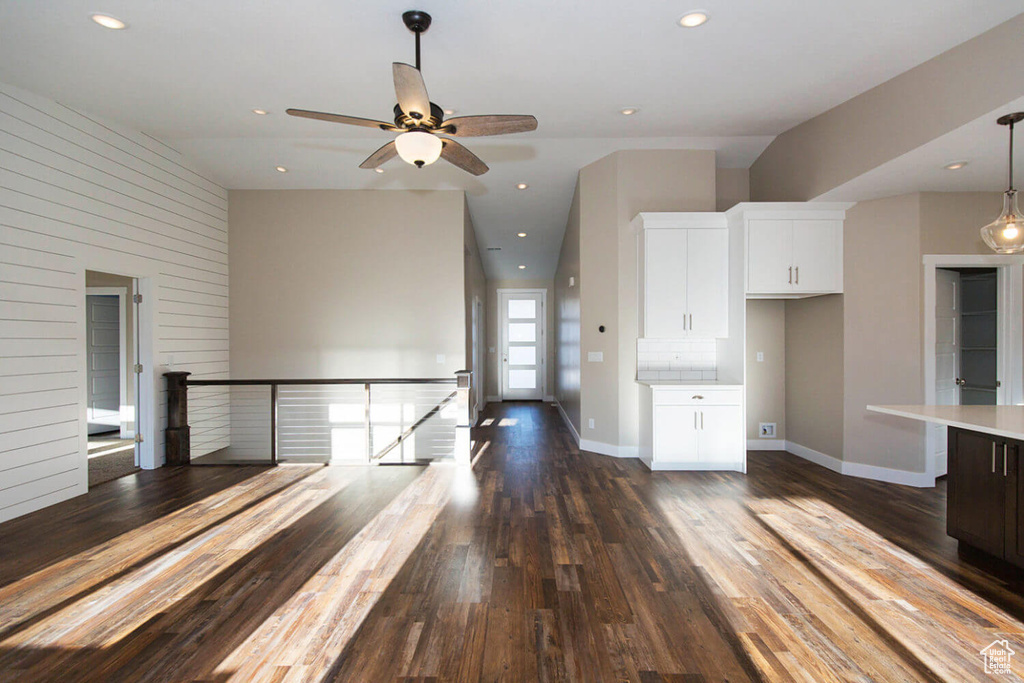 Kitchen with light countertops, white cabinetry, dark wood-style flooring, a ceiling fan, and baseboards