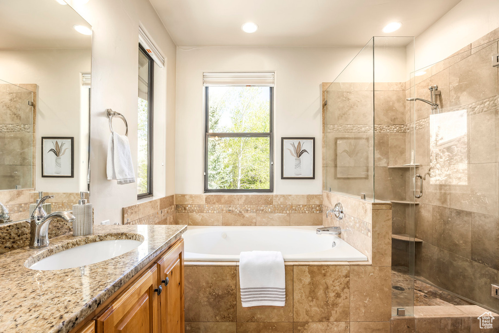 Bathroom with a tile shower, a garden tub, vanity, and recessed lighting