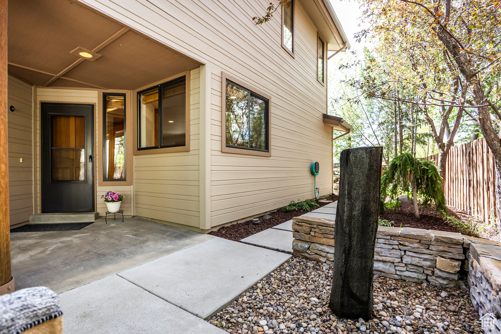 Entrance to property featuring fence and a patio