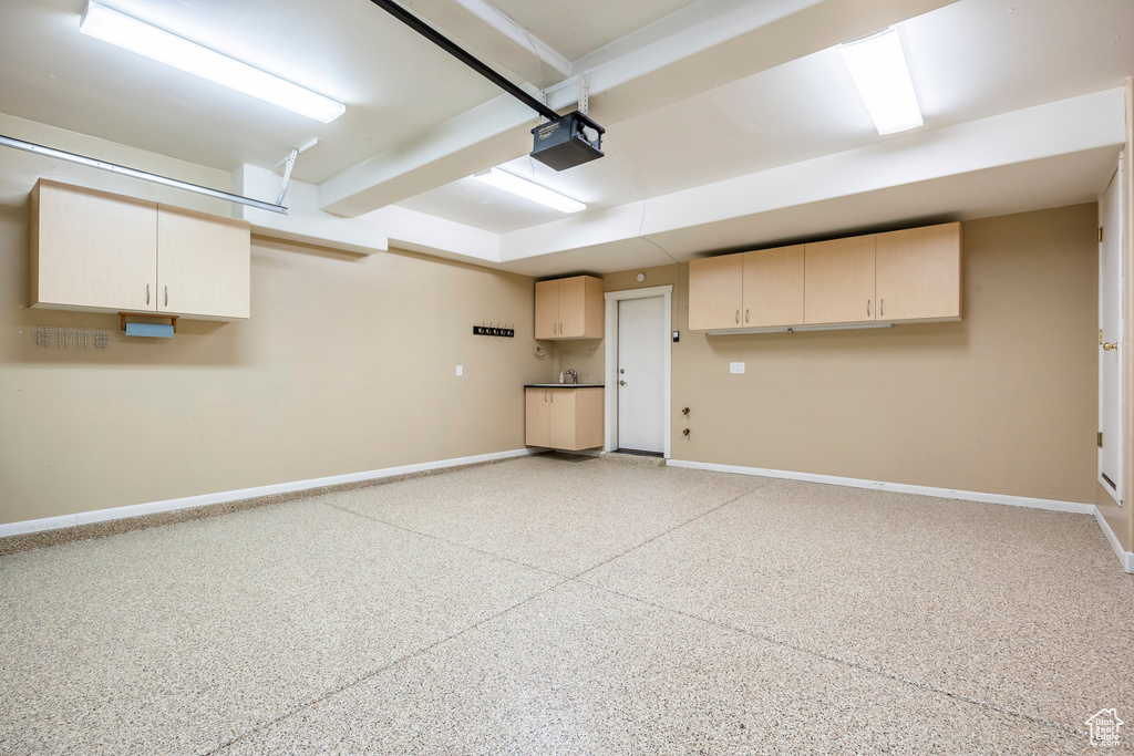 Garage featuring baseboards and a garage door opener