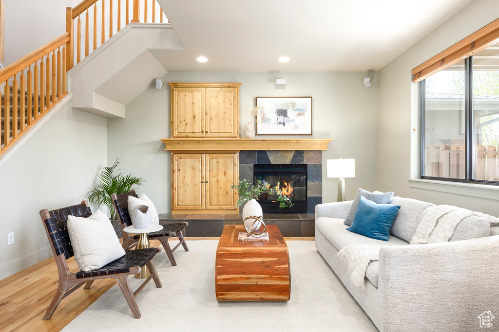 Living area featuring wood finished floors, recessed lighting, stairway, a fireplace, and baseboards