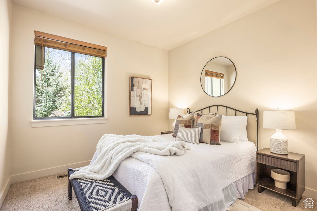 Bedroom with light colored carpet and baseboards