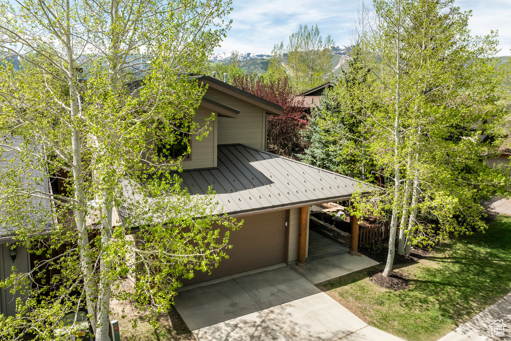 View of side of property with concrete driveway and a garage
