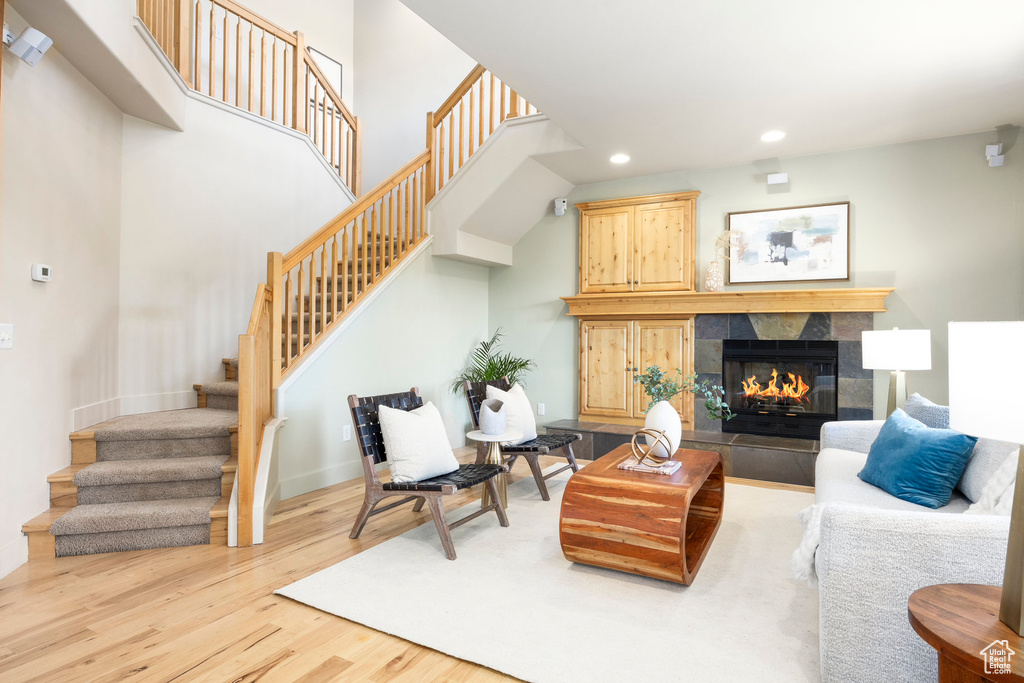 Living room with stairs, wood finished floors, a fireplace, recessed lighting, and baseboards
