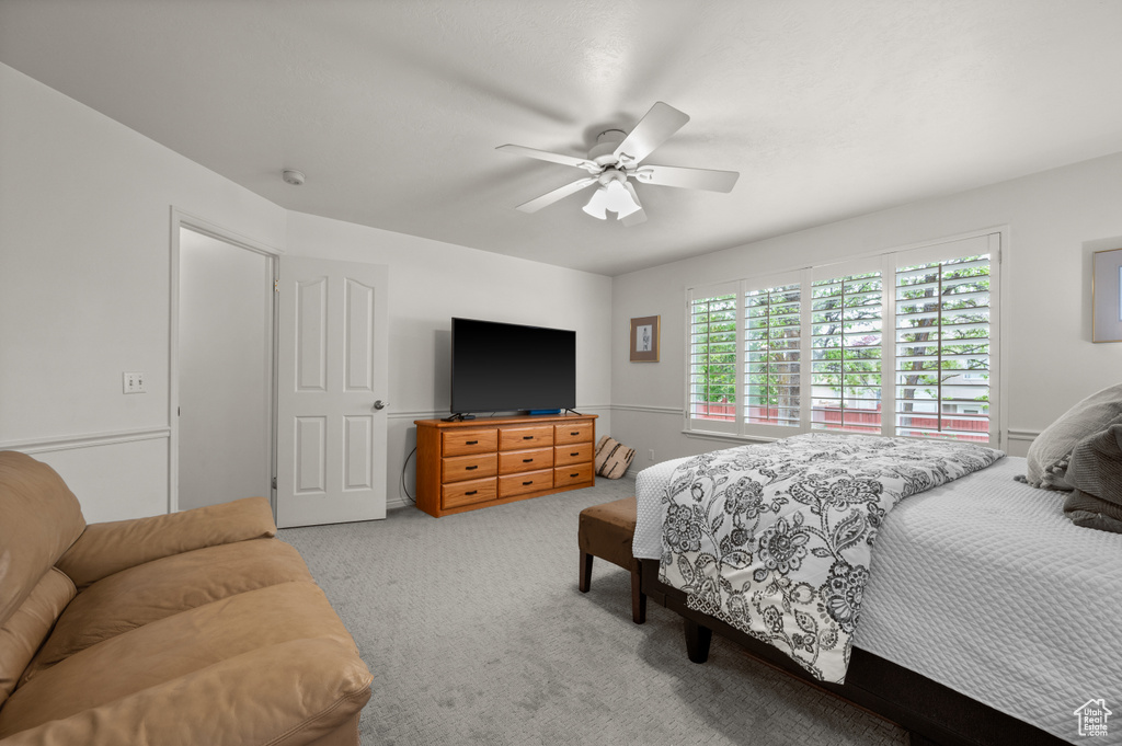 Carpeted bedroom featuring ceiling fan