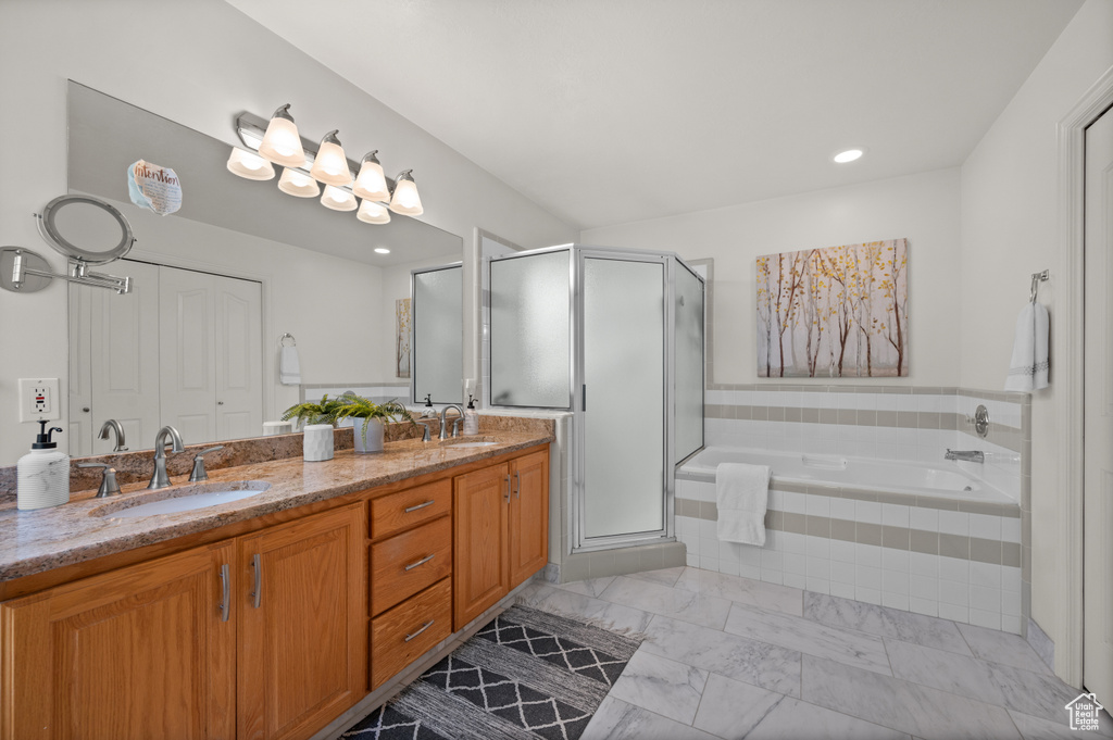Bathroom featuring double vanity, a shower stall, a garden tub, and recessed lighting