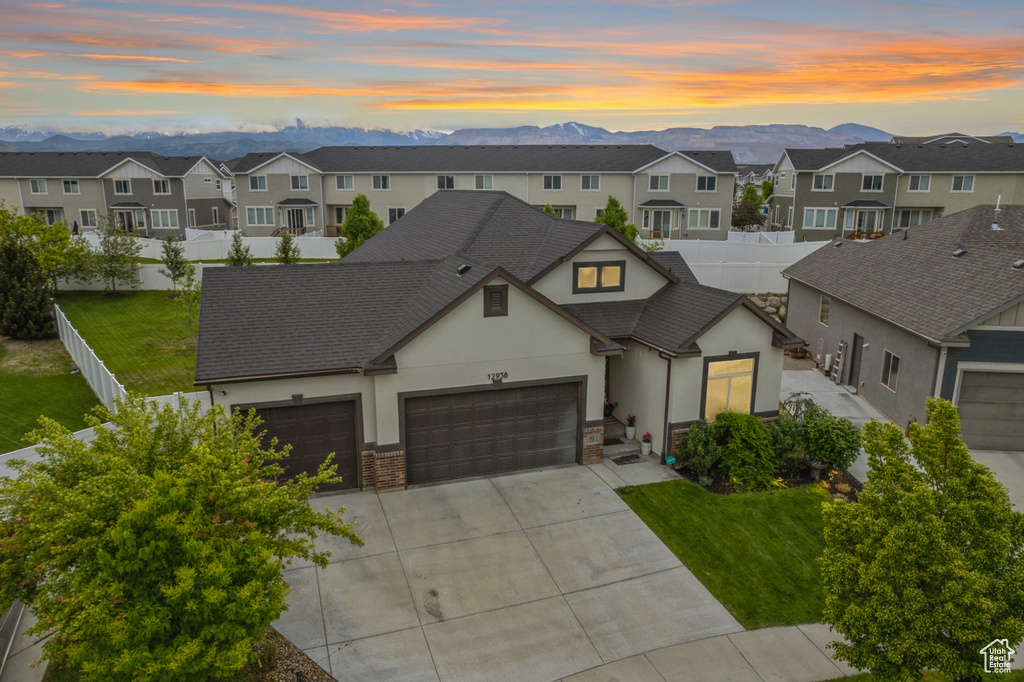 View of front of property with stucco siding, a residential view, a garage, concrete driveway, and roof with shingles