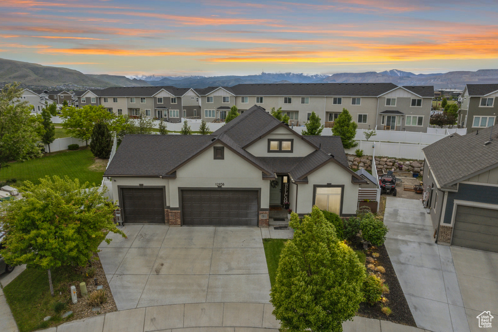 View of front of home with stucco siding, a mountain view, driveway, and a garage