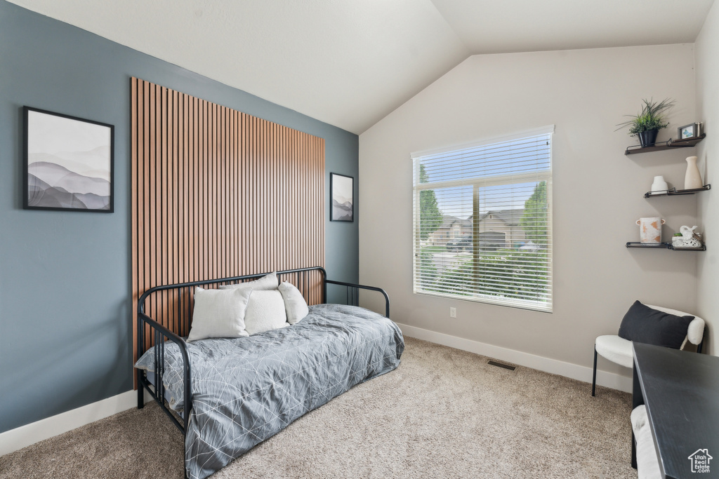 Bedroom with vaulted ceiling, carpet, and baseboards