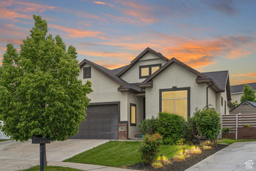 View of front of home featuring stucco siding, concrete driveway, and a shingled roof