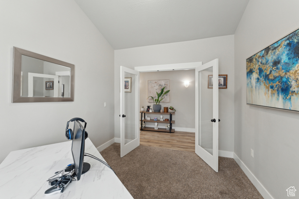 Carpeted office with french doors and baseboards