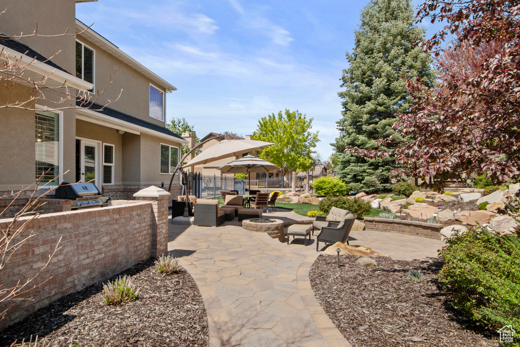 View of patio / terrace with an outdoor fire pit, fence, an outdoor kitchen, and area for grilling