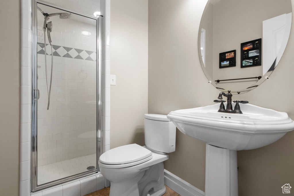 Full bathroom with a stall shower, baseboards, and toilet