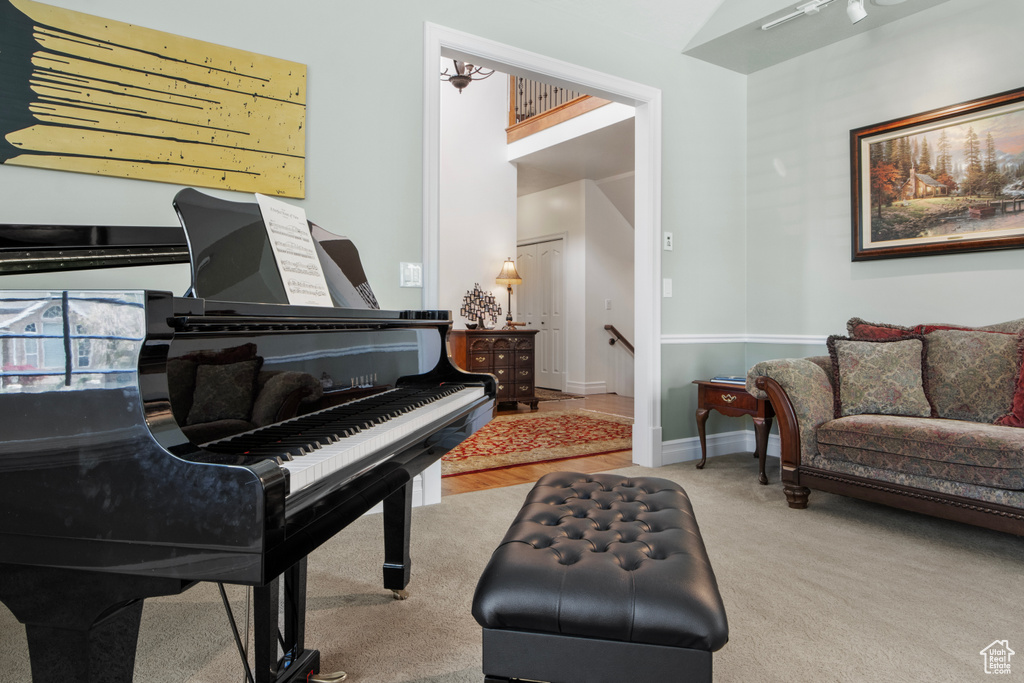 Sitting room featuring carpet flooring, an upstairs landing, and baseboards