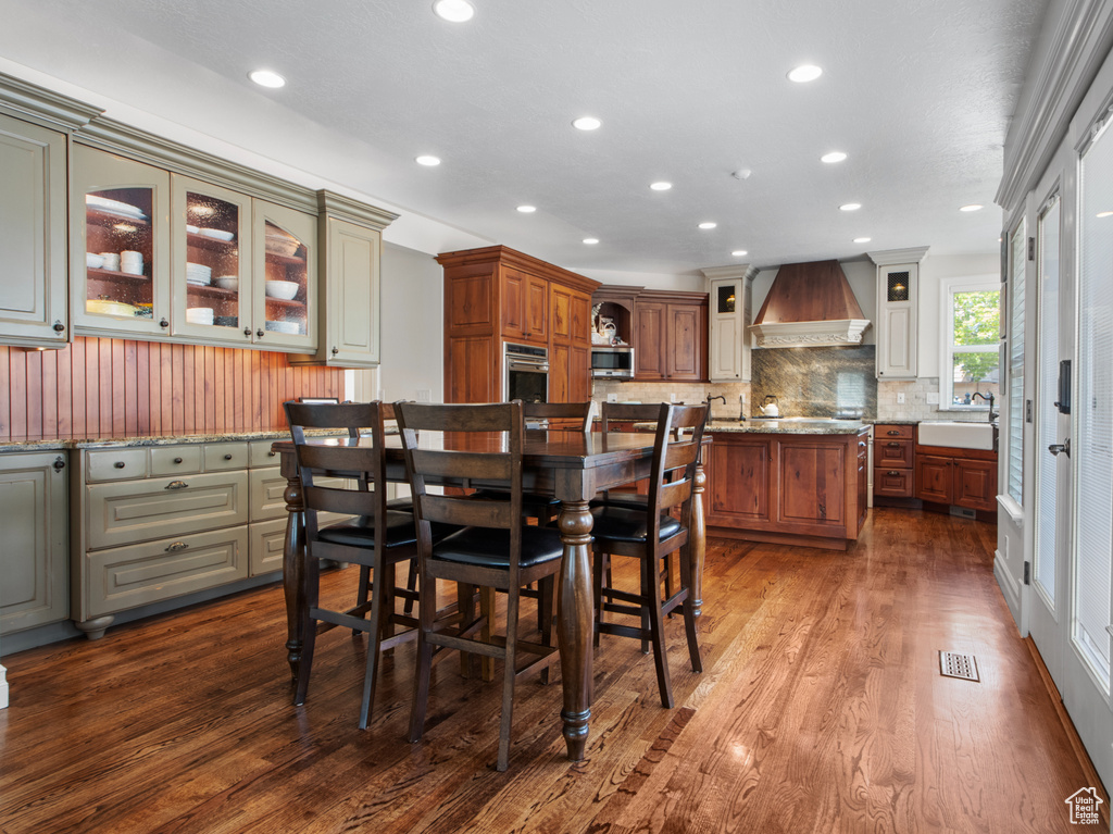 Dining space with dark wood-type flooring and recessed lighting