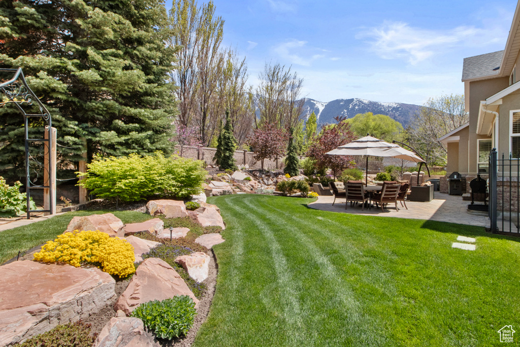 View of yard with fence, a patio, and a mountain view