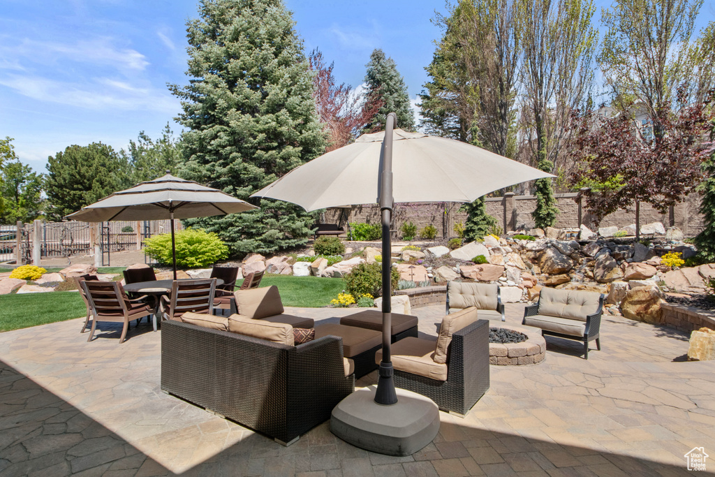 View of patio featuring an outdoor living space with a fire pit and fence