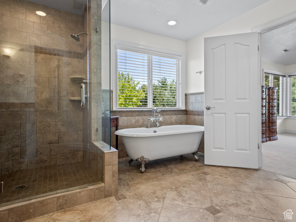 Full bath with a stall shower, visible vents, and a freestanding tub