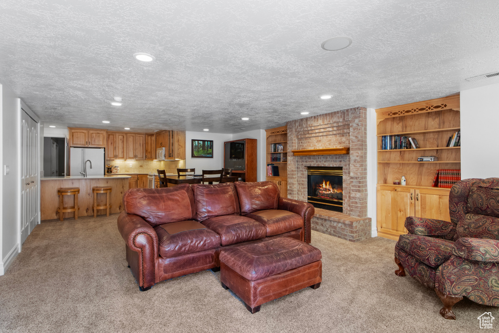 Living room featuring light carpet, a textured ceiling, visible vents, and recessed lighting