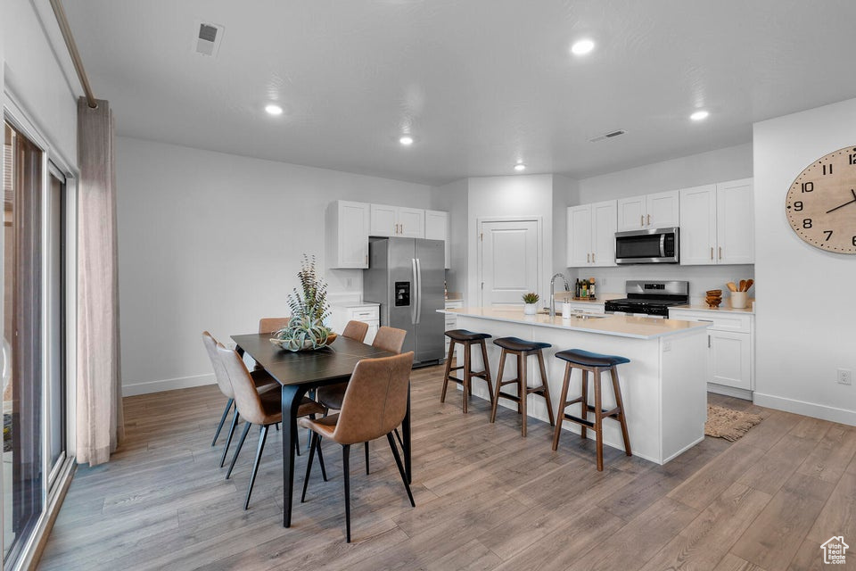 Dining area featuring light wood-style floors, baseboards, and recessed lighting