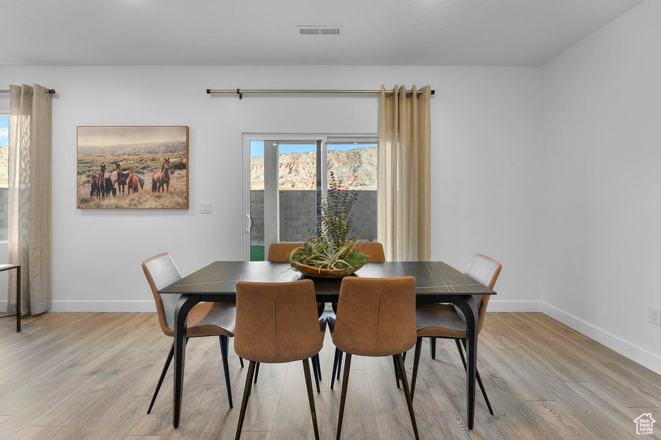 Dining area featuring light wood-style floors and baseboards