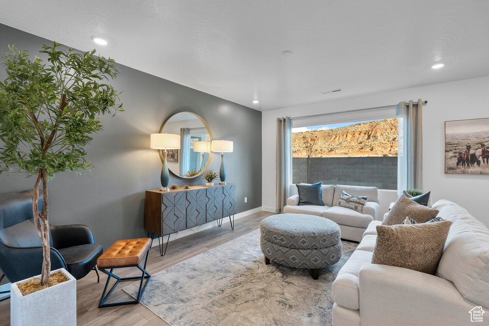 Living area with wood finished floors, baseboards, and recessed lighting