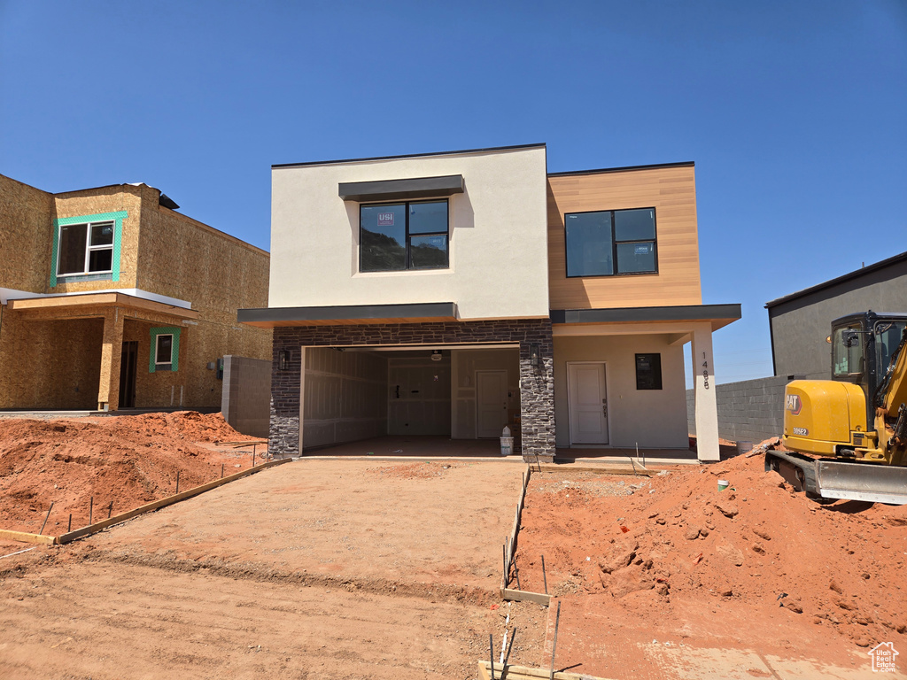 View of front of house featuring driveway, stucco siding, and an attached garage