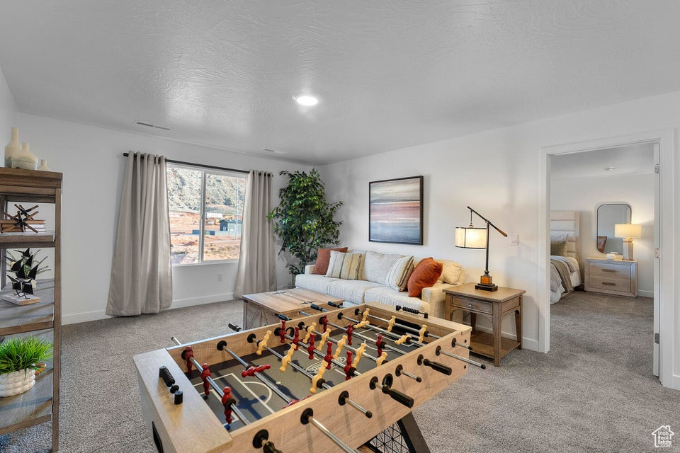 Recreation room featuring carpet floors and baseboards