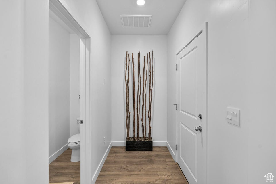 Entryway with wood finished floors, baseboards, and recessed lighting