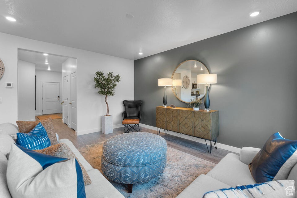 Living area with wood finished floors, recessed lighting, and baseboards