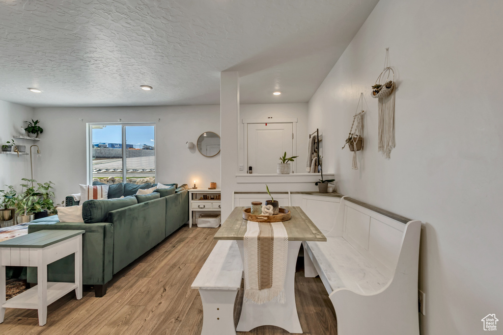 Dining space with light wood-style floors, a textured ceiling, and recessed lighting