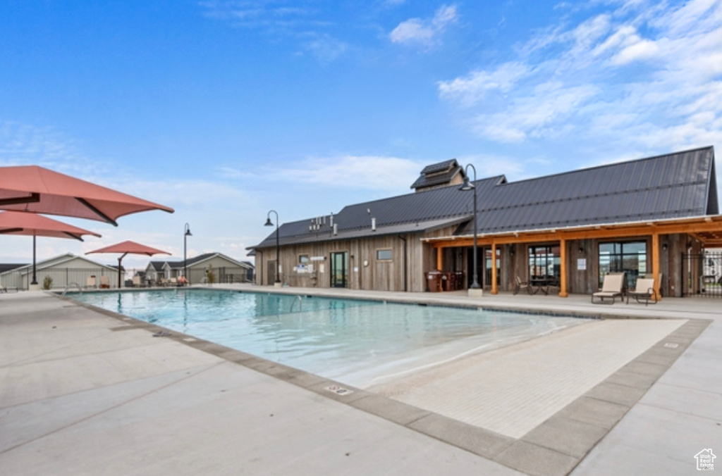 Community pool with a patio and fence