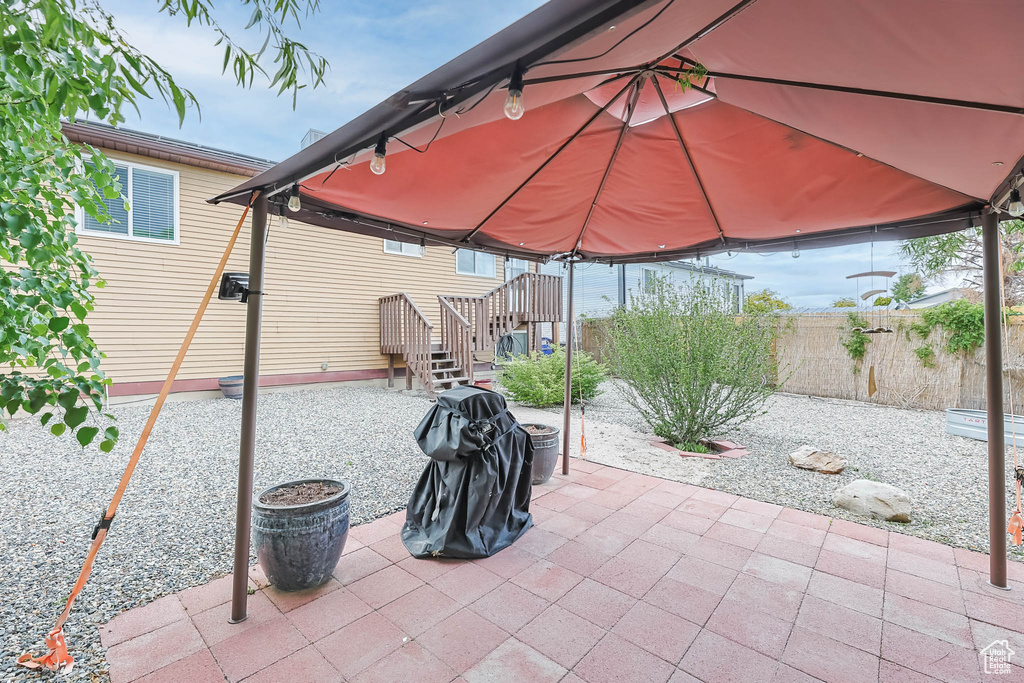 View of patio with a gazebo and fence