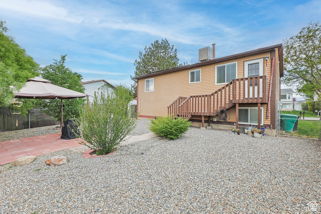 Back of house with a gazebo, fence, and a patio area