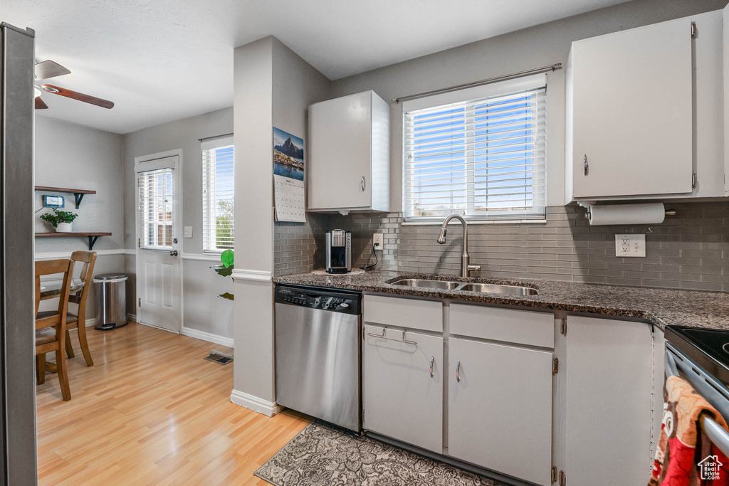 Kitchen with dishwasher, a sink, ceiling fan, light wood-style flooring, and tasteful backsplash