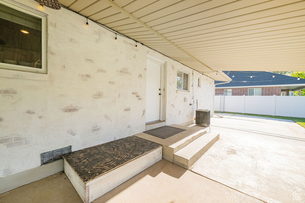 View of patio featuring fence and central air condition unit